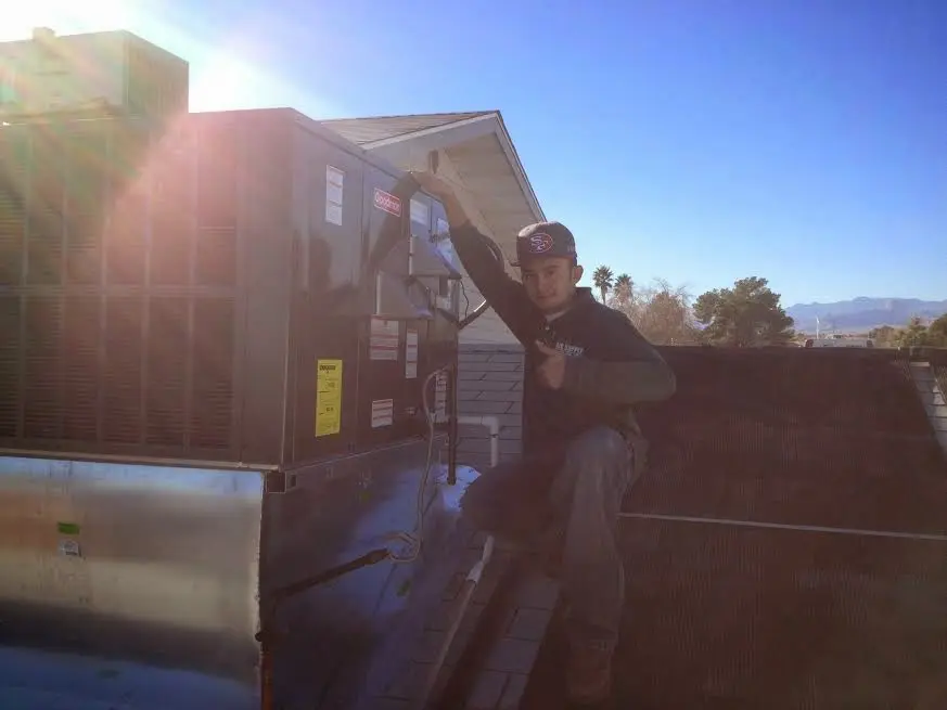 HVAC technician performing AC Tune-Up on a rooftop unit in New Paltz